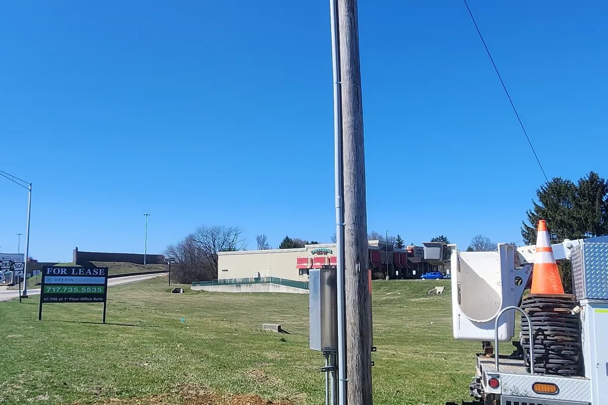 Newly set service pole with a bucket truck alongside